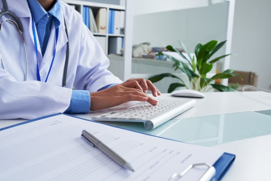 Medico sentado digitando em seu teclado